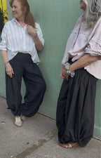 Two women wearing the Italian Pants front view and side view in Noir. relaxed fit