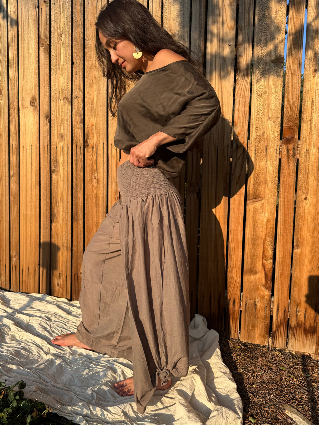 Detail of the Italian Pants showing their effortless drape and side ruching in velvet mushroom 